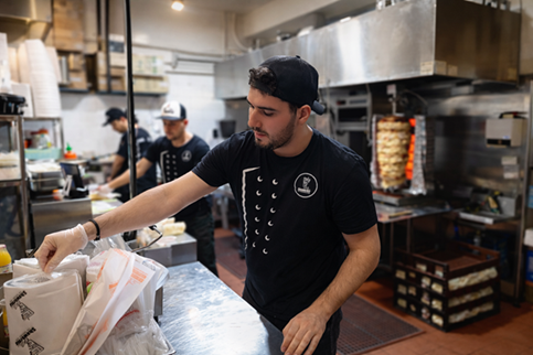 Team member wrapping a shawarma order